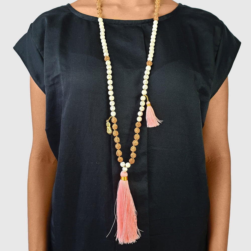 
                  
                    Load image into Gallery viewer, Handmade Buddha rudraksha and howlite mala necklace with pink tassel on model
                  
                
